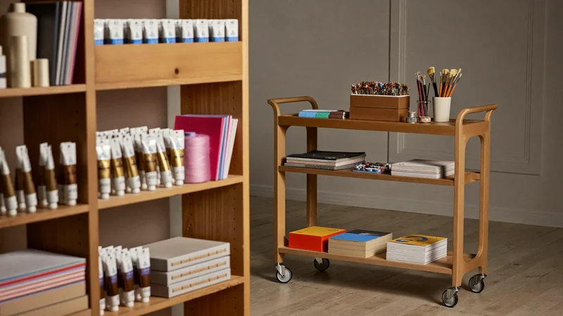 Illustrative tidy shelving and storage trolley with sorted yarn, paints, brushes and card stock